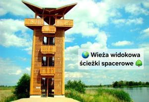 a wooden tower with a balcony on top of it at Rentumi Hostel Gryfino-Noclegi Pracownicze i turystyczne in Gryfino