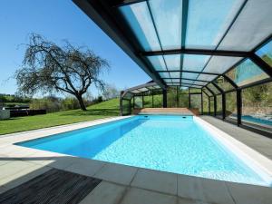 an indoor swimming pool with a glass roof at Modern Mansion in Vielsalm with Sauna and Private Pool in Vielsalm