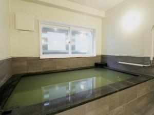 a pool of water in a bathroom with a window at Hotel Ichibokaku in Yamanouchi +100 photos