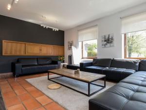 a living room with blue couches and a coffee table at Modern Mansion in Vielsalm with Sauna and Private Pool in Vielsalm