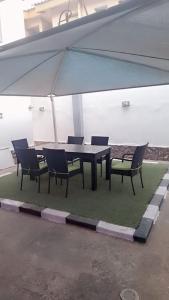 a table with chairs and an umbrella in a building at Zek's Place in Lagos