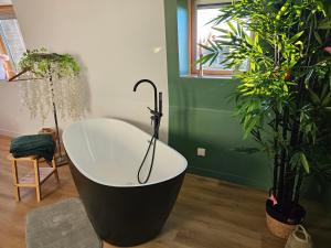 a bath tub in a room with potted plants at Appartement tout confort à proximité de Lille, Lens et Arras in La Bassée