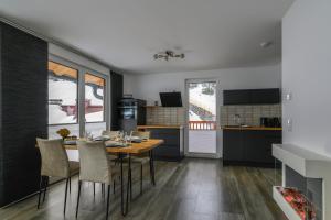a kitchen and dining room with a table and chairs at Ferienwohnung Klugis in Gosau