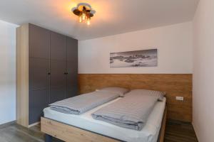 a bedroom with a bed and a ceiling fan at Ferienwohnung Klugis in Gosau