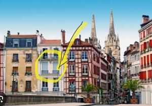een geel symbool in een stad met gebouwen bij Super T3 centre historique près halles in Bayonne