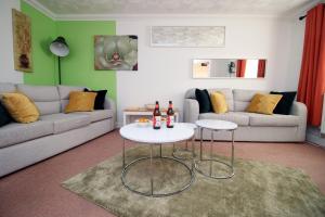 uma sala de estar com um sofá e duas mesas em 3 Bed with Free Parking - Merriotts 1 by Tŷ SA em Newport