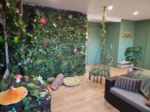 a living room with a green wall with plants at Appartement tout confort à proximité de Lille, Lens et Arras in La Bassée