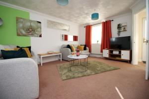 a living room with a couch and a tv at 3 Bed with Free Parking - Merriotts 1 by Tŷ SA in Newport