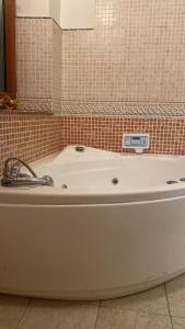 y baño alicatado con bañera blanca. en Luxury Room Cosenza, en Cosenza