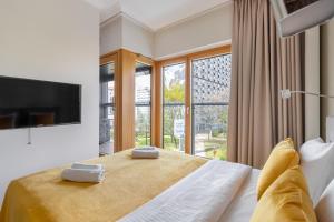 a bedroom with a bed and a large window at Golden Apartments Warsaw - Mennica Residence in Warsaw