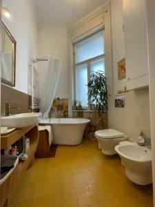 a bathroom with a tub and a toilet and a sink at Amber Pearl Apartment 2 rooms and 2 bathrooms at Kálvin Square in Budapest