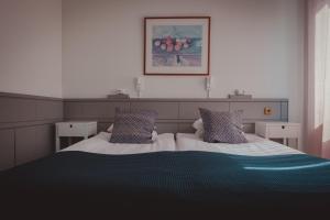 - une chambre avec un lit et une photo sur le mur dans l'établissement Stadshotellet Lidköping, à Lidköping