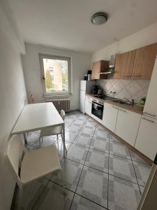 a kitchen with white cabinets and a table and chairs at Domum 7 Ferien- Monteurapartments inkl Wlan und Waschmaschine in Kamen in Kamen