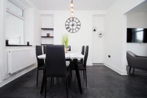 a dining room with a table and chairs at 3 Bedroom House in Mountain Ash Cynon View by TŷSA in Quakers Yard