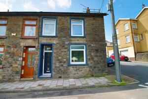 a brick house on the side of a street at 3 Bedroom House in Mountain Ash Cynon View by TŷSA in Quakers Yard