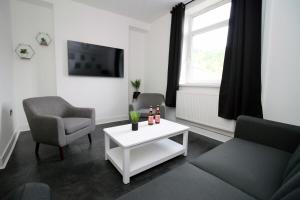 a living room with a couch and a table at 3 Bedroom House in Mountain Ash Cynon View by TŷSA in Quakers Yard