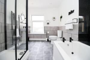 uma casa de banho branca com 2 WC e um lavatório em 3 Bedroom House in Mountain Ash Cynon View by TŷSA em Quakers Yard
