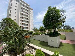 een tuin met planten en een hoog gebouw bij Hovah Luxury Homes' 2BR Apartment in Accra