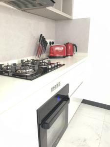 - une cuisine équipée d'une cuisinière et d'un appareil rouge dans l'établissement Luxury Beach Condo Dehiwala Mt Lavinia, à Watumulla