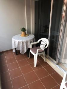 a table and a chair on a balcony at Praia da rocha in Portimão