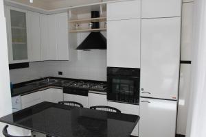 a kitchen with white appliances and a black counter top at Miramare in Arma di Taggia