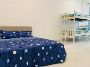 ein Schlafzimmer mit einem blauen Bett mit Polka-Punkten in der Unterkunft 30pax Desaru Pengerang Home in Pengerang