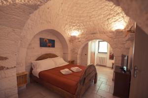 ロコロトンドにあるイ トゥルーリ ディ バディの石造りのベッドルーム1室(ベッド1台付)