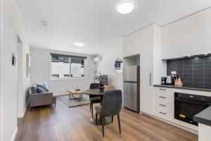 una cucina e un soggiorno con tavolo e sedie di 1-Bed in Vibrant St Kilda Perfect for a Staycation a Melbourne
