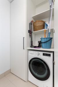 una lavatrice bianca in una lavanderia bianca di 1-Bed in Vibrant St Kilda Perfect for a Staycation a Melbourne