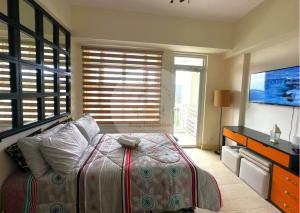 ein Schlafzimmer mit einem großen Bett und einem TV in der Unterkunft Twin Lakes Tagaytay - Cozy Staycation with Sglobal in Laurel