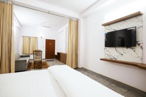 um quarto com uma cama e uma televisão na parede em Devdarshan Hotel & Restaurant em Udaipur