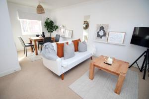 a living room with a white couch and a table at Alicia's House by Tŷ SA in Newport