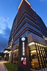 un edificio alto con un reloj delante en Hotel Intrendy en Taishan