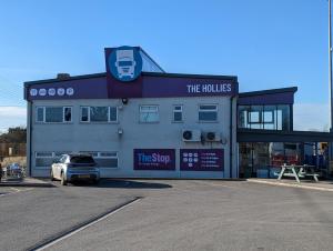 un edificio con un coche aparcado delante de él en The Stop - Hollies Truckstop Café en Cannock
