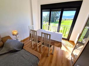 uma sala de estar com uma mesa e cadeiras e uma janela em Apartamento Playa Foz em Foz