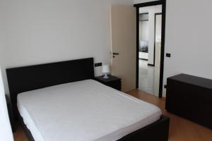 a bedroom with a white bed and a glass door at Miramare in Arma di Taggia