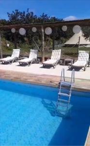 una piscina con sillas y una piscina en Quinta da Boa Sorte, en Estói