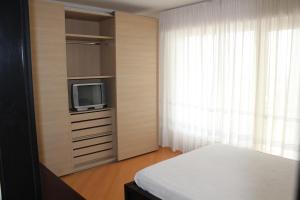 a bedroom with a bed and a tv and a window at Miramare in Arma di Taggia