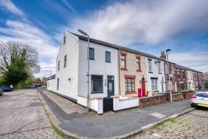 um edifício branco ao lado de uma rua em 4-BR Chic Spacious House with Parking, Central Bolton, Links to Manchester, Sleeps - 11 by Blue Puffin Stays em Farnworth