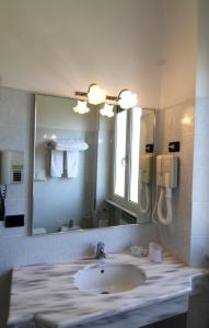 a bathroom with a sink and a large mirror at Hotel Reale in Fiuggi