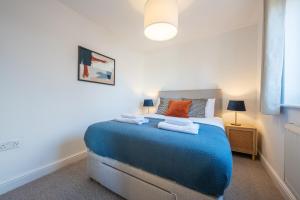 Un dormitorio con una cama azul con toallas. en Atlanta's Residence by Tŷ SA, en Newport