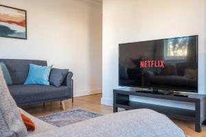 a living room with a flat screen tv on a table at Atlanta's Residence by Tŷ SA in Newport