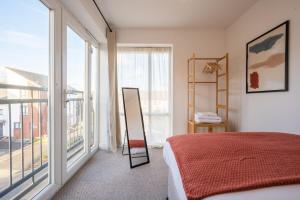 sypialnia z łóżkiem i dużym oknem w obiekcie Atlanta's Residence by Tŷ SA w mieście Newport