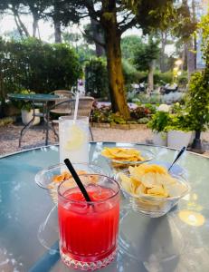 une table avec deux bols de chips et une boisson dans l'établissement Des Bains 138 B&B, à Milano Marittima