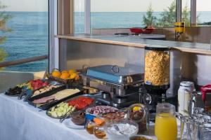 una mesa buffet con comida en una mesa con el océano en Seafalios, en Kalamaki