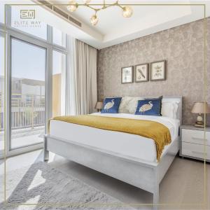 a bedroom with a bed and a large window at Impressive 3BR Villa-Akoya in Dubai