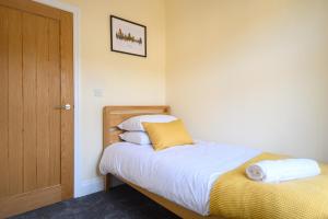 1 dormitorio con 1 cama y puerta de madera en Beechwood House by Tŷ SA - ICC & Celtic Manor en Newport