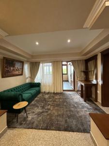 Pensiunea Eden في أغابيا: غرفة معيشة مع أريكة خضراء وطاولة