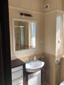 a bathroom with a sink and a mirror at Apartament Klaudia in Stegna