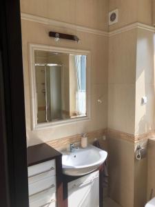 a bathroom with a sink and a mirror at Apartament Klaudia in Stegna +6 photos